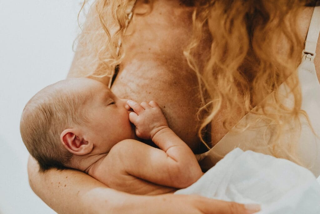 Cross Cradle Breastfeeding Position Example. Mother breastfeeding her baby.